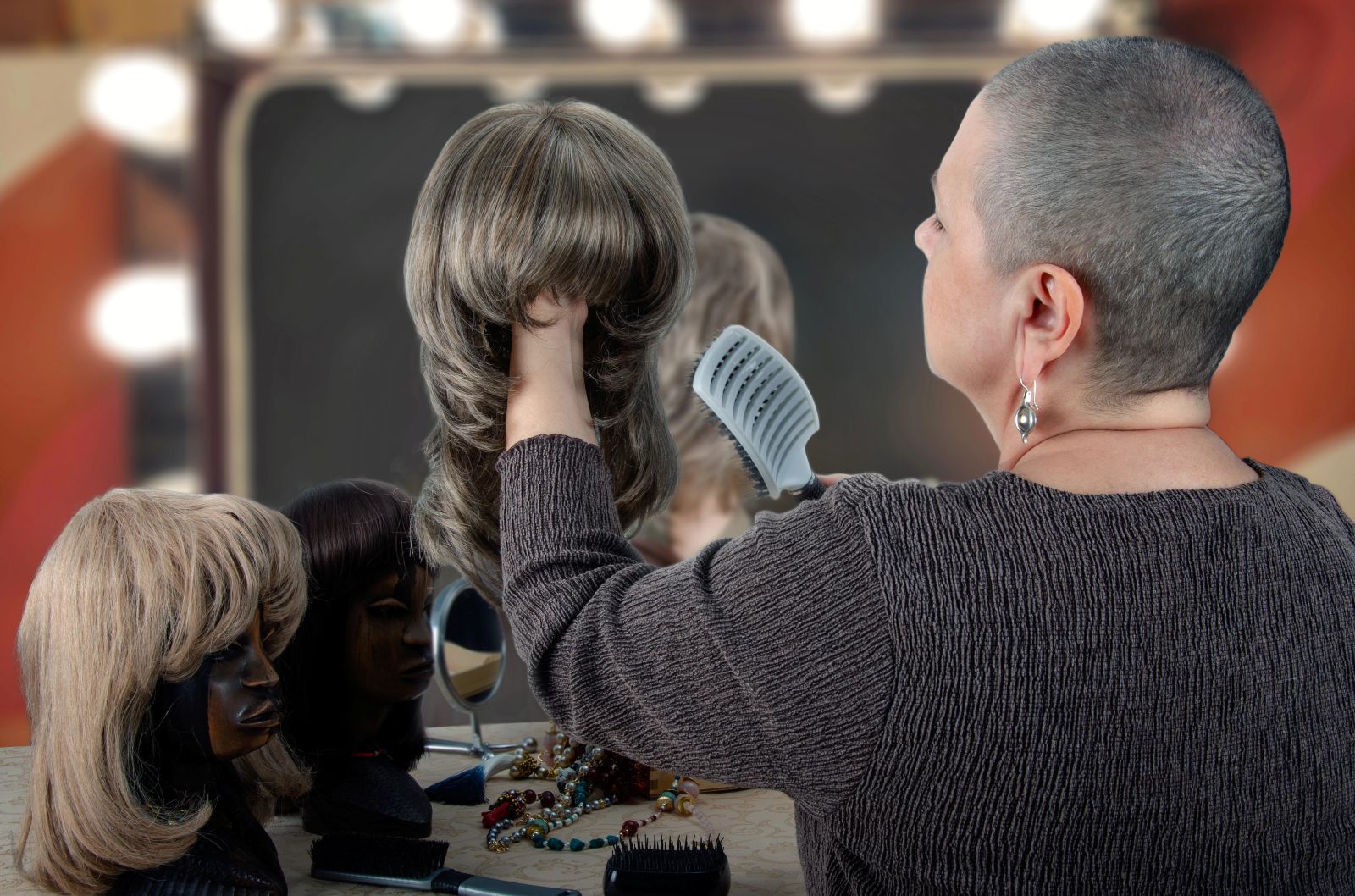 person with shaved head brushing wig