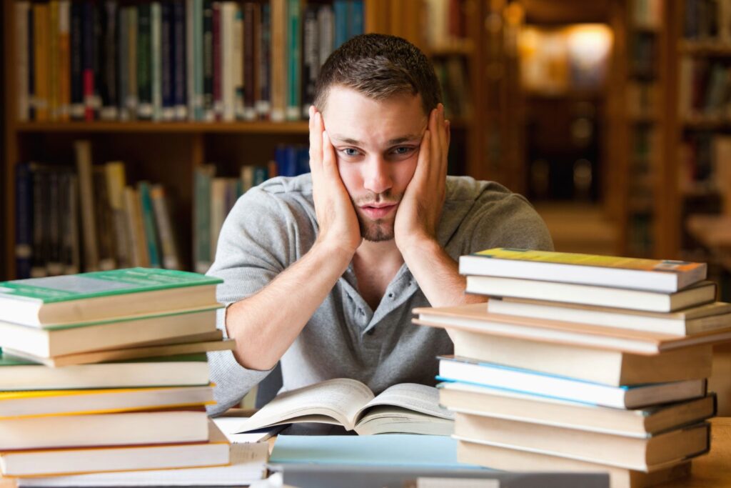 stressed student with piles of books