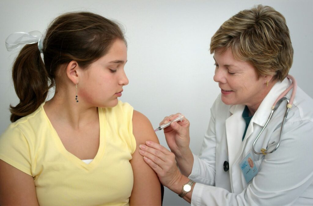 young woman getting injection from doctor