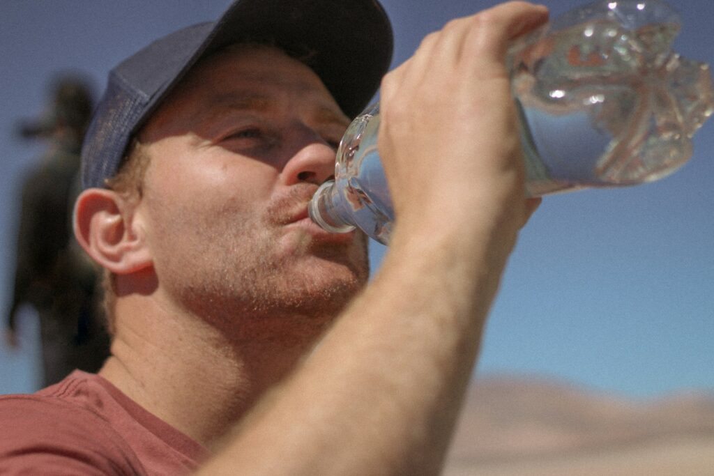 man outside drinking water