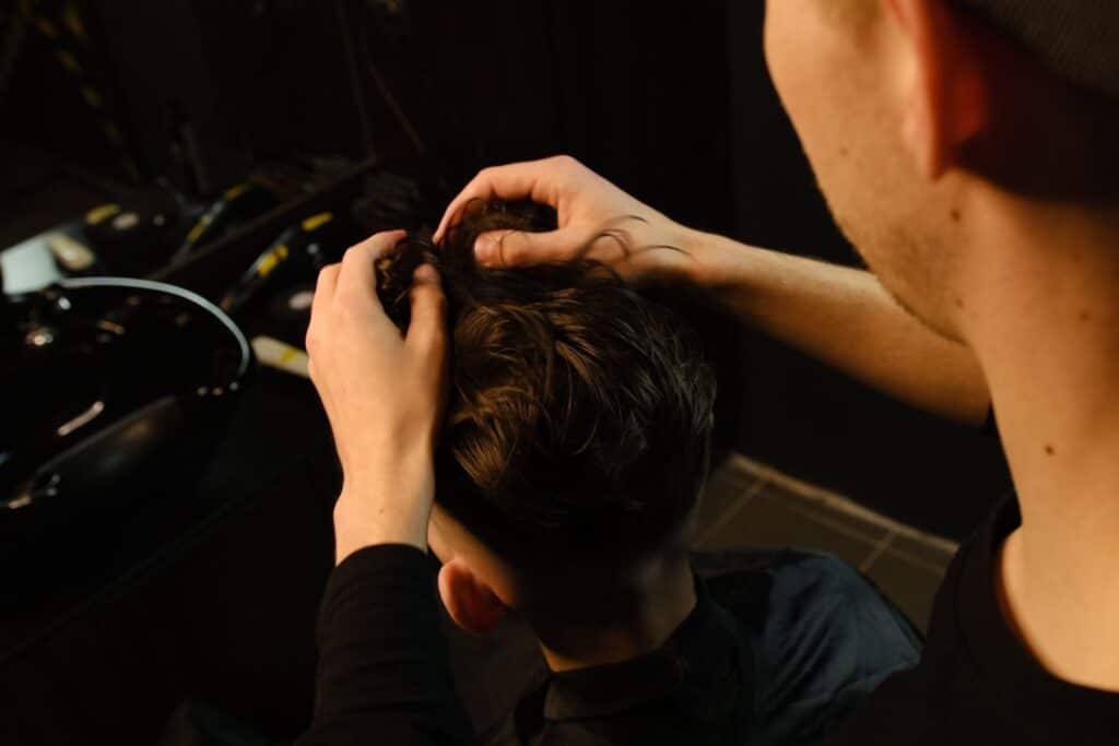man getting hair system piece attached