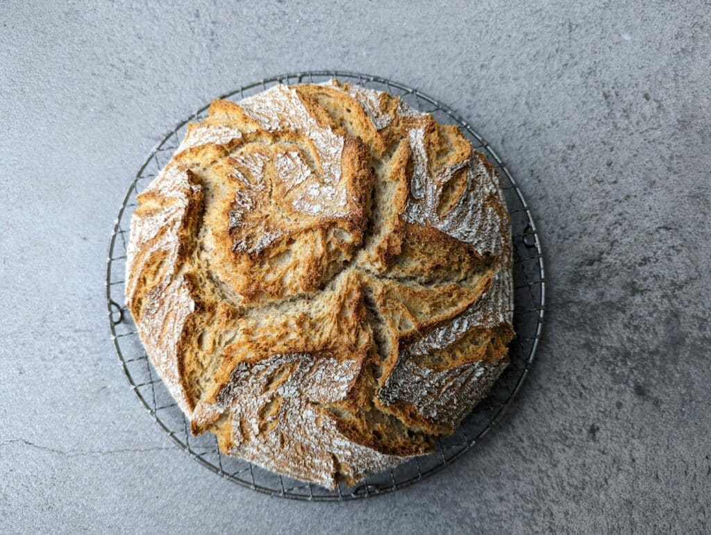 Freshly baked Irish soda bread loaf cooling on a metal wire rack.
